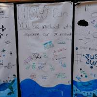 Poster that reads "How can YOU be involved with improving our watershed". The poster is full of written ideas and watershed drawings like water and fish.